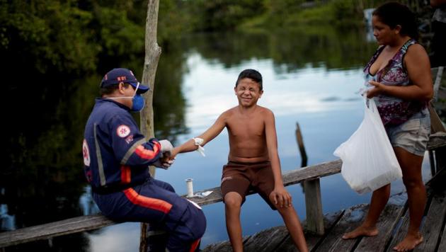 A healthcare worker treats a child who has an infection, as his mother looks on, in front of their home at the riverside community Menino de Deus, as healthcare workers visit riverside communities to check on residents during the coronavirus disease (COVID-19) outbreak, in the municipality of Portel, on Marajo island, Para state, Brazil, June 13, 2020. (Representational)(REUTERS) A healthcare worker treats a child who has an infection, as his mother looks on, in front of their home at the riverside community Menino de Deus, as healthcare workers visit riverside communities to check on residents during the coronavirus disease (COVID-19) outbreak, in the municipality of Portel, on Marajo island, Para state, Brazil, June 13, 2020. (Representational)(REUTERS)