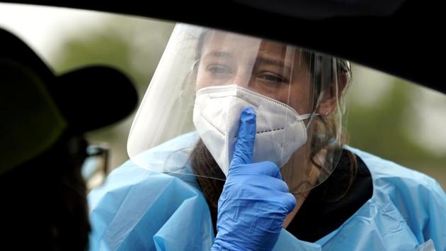 Healthcare professional Kenzie Anderson, right, explains how she will take a sample to a patient at a United Memorial Medical Center COVID-19 testing site Friday, June 26, 2020, in Houston. (AP) Healthcare professional Kenzie Anderson, right, explains how she will take a sample to a patient at a United Memorial Medical Center COVID-19 testing site Friday, June 26, 2020, in Houston. (AP)