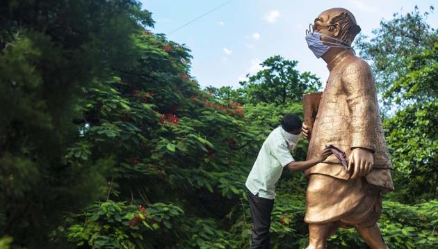 A worker cleans the statue of “Common Man” –wearing a facemask, at Symbiosis Vishwabhavan campus, in Pune.(Pratham Gokhale/HT Photo) A worker cleans the statue of “Common Man” –wearing a facemask, at Symbiosis Vishwabhavan campus, in Pune.(Pratham Gokhale/HT Photo)