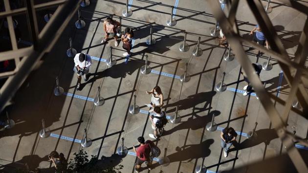People queue up prior to a visit to the Eiffel Tower on June 25. According to a report by Reuters, visitors can for now access the 324 metre high (1,062 feet) tower only via staircases until early July, as elevators remain off-limits because of safety considerations. (Thibault Camus / AP)