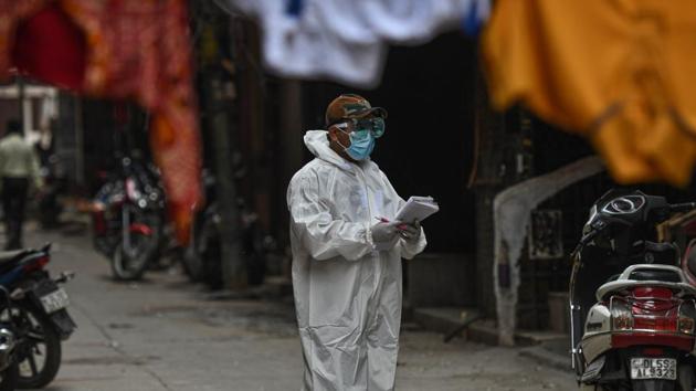 A health worker in PPE conducts a door to door screening survey for coronavirus in Karol Bagh's Ragarpura area, in New Delhi.(Biplov Bhuyan/HT PHOTO)