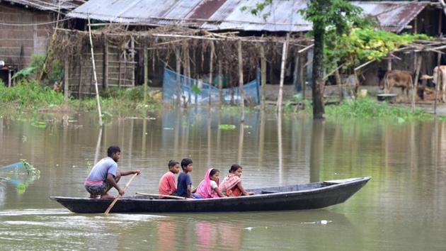 Locals cross a flooded area on a boat in Nagaon district, Assam, on June 27. With heavy rainfall continuing in most parts of the state, the flood situation in Assam has worsened. Over 2.53 lakh people have been affected in 16 of the state’s 33 districts. (PTI)