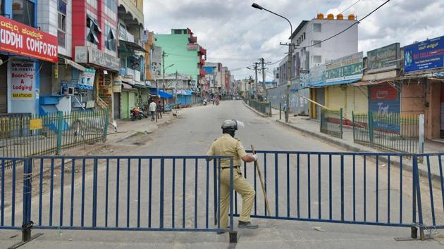 A policeman stands guard at a barricaded commercial street in Bangalore on June 25. There were 14,229 Covid-19 patients who were declared cured in a single day, data showed on June 27. Since June 13, the number of cured patients has been more than the active cases in the country. (Manjunath Kiran / AFP)