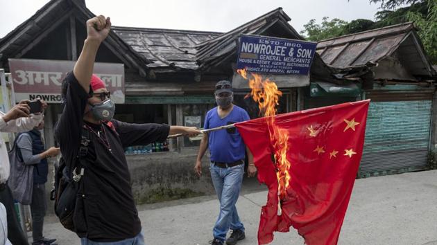 Tenzin Tsundue, an exile Tibetan activist burns a Chinese national flag during a one-man protest in Dharmsala, India.(AP)