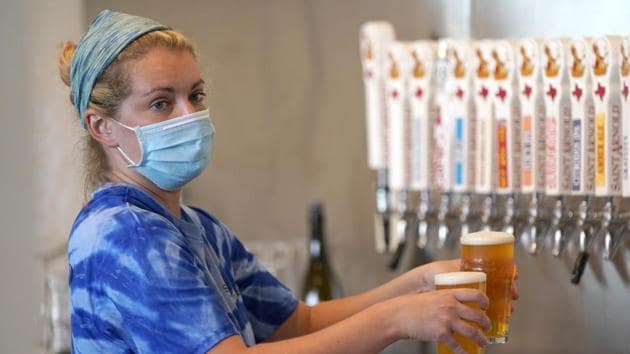 Bartender Katie McGranahan pours beers at the Saint Arnold Brewing Company Friday, June 26, 2020, in Houston.(AP)