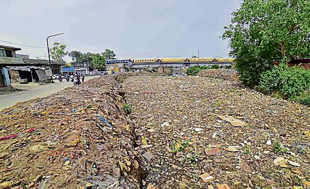 Heaps of waste lying on the banks of Buddha Nullah near New Kundanpuri bridge in Ludhiana on Saturday.(Gurpreet Singh/HT)