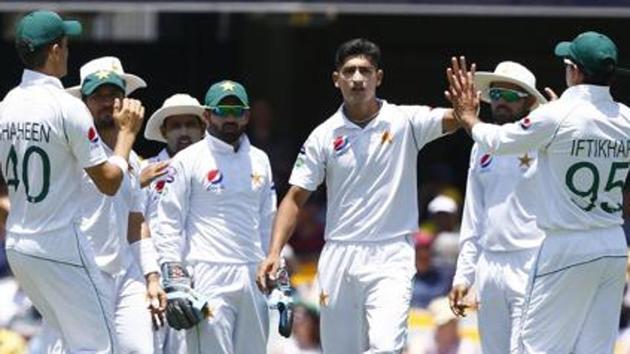 Pakistan's Naseem Shah, center, celebrates with his team after getting the wicket of Australia's David Warner during their cricket test match in Brisbane, Australia.(AP)