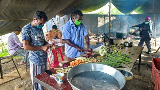 Circus manager Biju Nair (C) along with others prepares food in their tent at the Rambo Circus in Airoli. The circus had managed only four shows before they had to shut down. The peak holiday season when schools are closed for summer came and went and the troupe stayed put, right where they had been since February. (Mitesh Bhuvad / PTI)