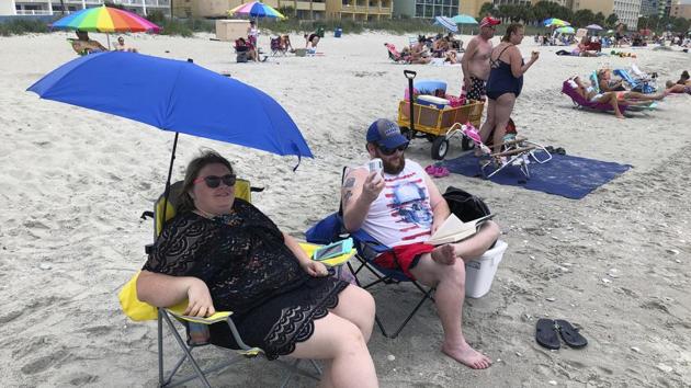 Tabatha Johnson, left, and her husband, Mark, enjoy the first day of vacation, Thursday, June 18, 2020, in Myrtle Beach, SC Across America, people are leaving their cares — and sometimes their masks — at home after months of worry about the virus as Southern states like South Carolina open hotels and restaurants and like Myrtle Beach advertise “Yes, the beach is open!”(AP)