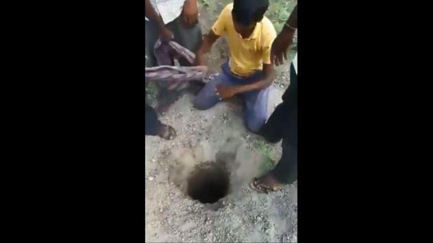 The image shows the men around the hole where the goat got stuck.(Screengrab)