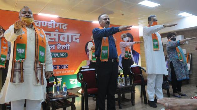 BJP city president Arun Sood and party members taking part in a virtual rally to highlight the achievements of the Narendra Modi-led NDA government at the party office in Sector 33, Chandigarh, on Sunday.(Keshav Singh/HT)