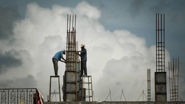 Labourers working on an under-construction building are pictured against large clouds in Vijayawada on June 26. “The large-scale features which ensured we have a good monsoon are a neutral El Nino and neutral Indian Ocean Dipole (IOD),” IMD director general M Mohapatra told HT. (PTI)