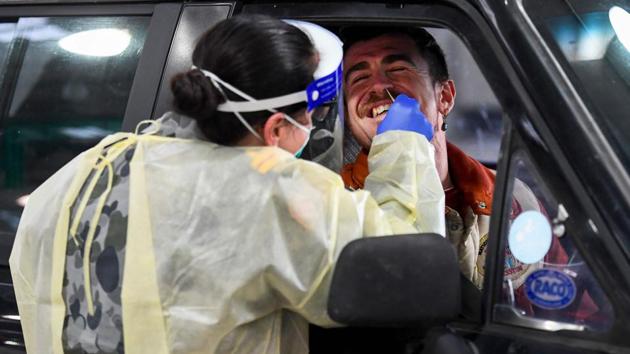 A member of the Australian Defence Force (L) takes a swab for a COVID-19 coronavirus test on a member of the public in Melbourne on June 27. Renewed surges in COVID-19 infections remain a looming threat raising fears of second waves in nations like Australia, Japan, China or New Zealand that have claimed to have contained the epidemic. (William West / AFP)