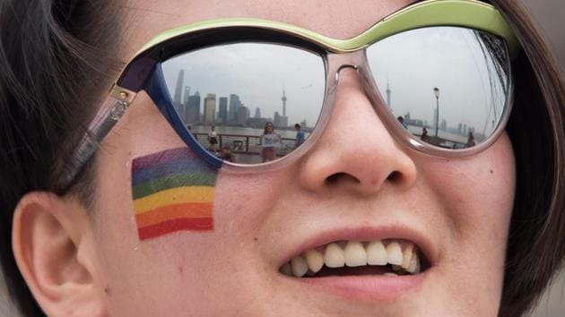 This file photo taken on June 13, 2015 shows the Bund in front of the financial district of Pudong reflected in the glasses of a participant of the Shanghai Pride as she poses for pictures during a break in Shanghai. - Despite a shakeup of the country's marriage law in May 2020 -- and a groundswell of public support for same-sex unions in the socially conservative country -- gay marriage is still unobtainable. (AFP) This file photo taken on June 13, 2015 shows the Bund in front of the financial district of Pudong reflected in the glasses of a participant of the Shanghai Pride as she poses for pictures during a break in Shanghai. - Despite a shakeup of the country's marriage law in May 2020 -- and a groundswell of public support for same-sex unions in the socially conservative country -- gay marriage is still unobtainable. (AFP)
