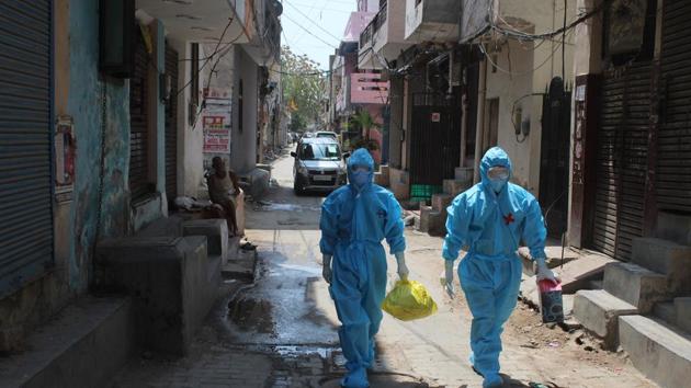 Health workers in PPE coveralls arrive to collect samples for coronavirus testing, during lockdown, at Arjun Nagar, Gurugram.(Yogendra Kumar/HT PHOTO)