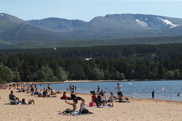 People enjoy the hot weather on the beach at Loch Morlich, near Aviemore, Scotland, Britain.(REUTERS)