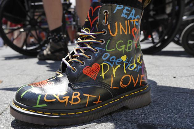 A person wears pride themed boots as they await the start of a queer liberation march for Black Lives Matter and against police brutality, Sunday, June 28, 2020, in New York. The march commemorated the 50th anniversary of Pride after New York's normally massive gay Pride march was cancelled due to concerns over the spread of coronavirus. (AP)
