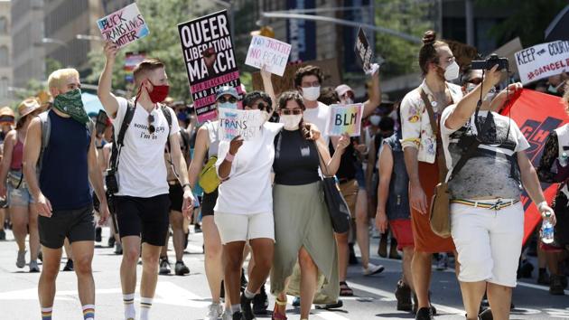 People hold signs as they participate in a queer liberation march for Black Lives Matter and against police brutality, Sunday, June 28, 2020, in New York. (AP) People hold signs as they participate in a queer liberation march for Black Lives Matter and against police brutality, Sunday, June 28, 2020, in New York. (AP)