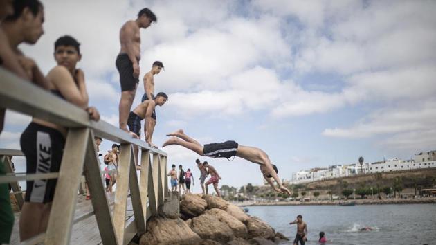 Boys jump into a river to cool down after lockdown measures were lifted in Rabat, Morocco on June 26. In newly opened public spaces, every moment of outdoor intimacy is savored, marking the end of months of lockdown. But as the world slowly tires to get on with their lives more lockdowns and social distancing measures will always be around the corner as long as the virus is not contained. (Mosa'ab Elshamy / AP)