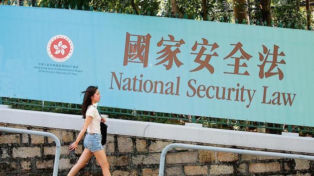 A woman walks past a banner promoting the controversial national security law in Hong Kong on Tuesday. (AP) A woman walks past a banner promoting the controversial national security law in Hong Kong on Tuesday. (AP)