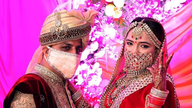 Rajasthan, June 25 (ANI): Bride and groom wear masks pose for photographs during their wedding ceremony, in Tonk on Thursday. (ANI Photo)(ANI)