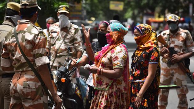 A group of women speak with paramilitary personnel near a containment zone in Reghar Pura on June 29. Delhi saw an increase of 141 in the number of containment zones over the weekend. The Centre and the Delhi government had decided to remap containment zones at a recent meeting chaired by Union Home Minister Amit Shah. (Sanchit Khanna / HT Photo)