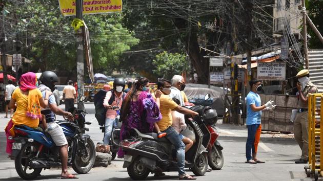 A Delhi Police personnel near a barricade at the Reghar Pura containment zone screens people looking to pass, on June 29. According to the findings of an advisory committee of the central government, 19% of the Covid-19 cases in Delhi so far have originated in containment zones. About 45% of these cases have been found in smaller clusters within such zones. (Sanchit Khanna / HT Photo)