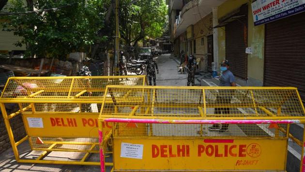 CRPF personnel man barricades blocking a lane at a containment zone in Lado Sarai on June 26. Containment zones are sealed areas where all residents are put under surveillance and most business and travel activities are prohibited. The areas are periodically sanitised and essential goods are delivered to people’s doorsteps so that residents do not have to venture out. (Amal KS / HT Photo)