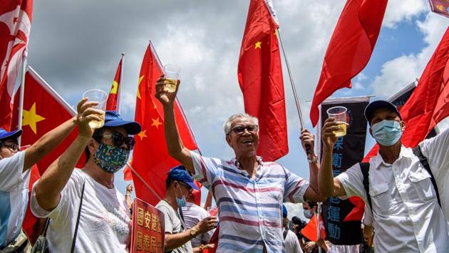 Pro-China supporters raise a toast with champagne during a rally celebrating the law’s passing in Hong Kong on June 30. “We hope the law will serve as a deterrent to prevent people from stirring up trouble,” Tam Yiu-Chung, Hong Kong’s sole representative on the Standing Committee of the National People’s Congress, was quoted by AP while addressing media. “Don’t let Hong Kong be used as a tool to split the country.” (Anthony Wallace / AFP)