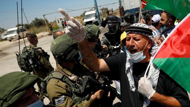 A demonstrator holding a Palestinian flag gestures in front of Israeli forces during a protest against Israel's plan to annex parts of the occupied West Bank, in Haris.(REUTERS)