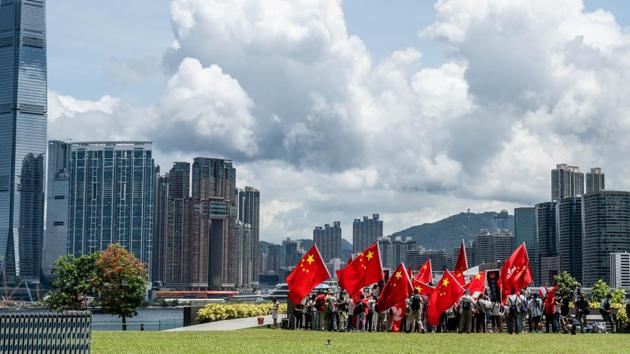 Government supporters wave Chinese and Hong Kong Special Administrative Region (HKSAR) flags at Tamar Park to celebrate the passage of the national security law in Hong Kong on June 30. China’s top legislative body, the National People’s Congress Standing Committee, had earlier in the day unanimously approved the security law for Hong Kong at the end of a three-day meeting in Beijing. (Lam Yik / Bloomberg)
