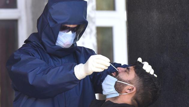A medical worker collects sample from a man for COVID-19 tests at a quarantine centre in Srinagar. (HT FILE PHOTO) A medical worker collects sample from a man for COVID-19 tests at a quarantine centre in Srinagar. (HT FILE PHOTO)