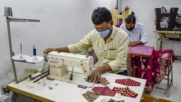 Workers stitch designer face masks at Trimula store in Mumbai. (Kunal Patil / PTI) Workers stitch designer face masks at Trimula store in Mumbai. (Kunal Patil / PTI)