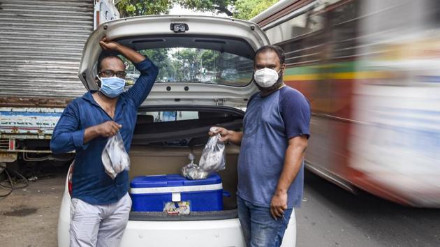 Amit Harlkar, co-owner of Lunch Home and Chef, and Vikrant Ughade, owner of a pest control firm, pose for a photograph while delivering fish to their customers amid the coronavirus lockdown. (Kunal Patil / PTI) Amit Harlkar, co-owner of Lunch Home and Chef, and Vikrant Ughade, owner of a pest control firm, pose for a photograph while delivering fish to their customers amid the coronavirus lockdown. (Kunal Patil / PTI)