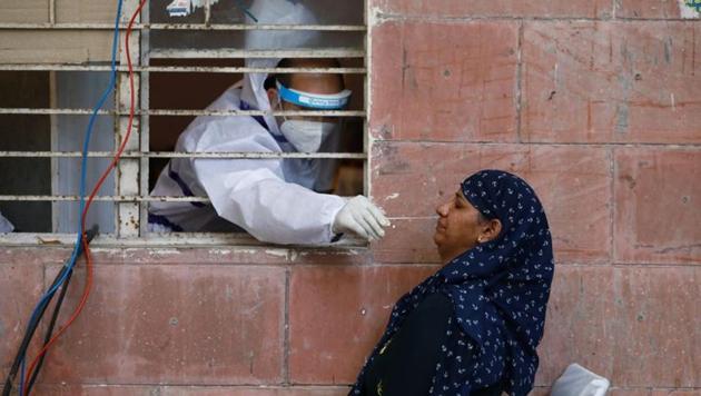 A medical worker collects a sample from a woman at a centre to conduct tests for the coronavirus disease (COVID-19), amidst its spread in New Delhi, India June 25, 2020.(REUTERS) A medical worker collects a sample from a woman at a centre to conduct tests for the coronavirus disease (COVID-19), amidst its spread in New Delhi, India June 25, 2020.(REUTERS)