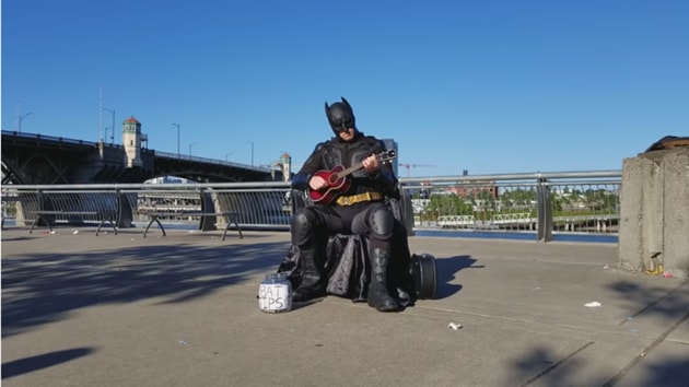 The image shows a person dressed as Batman playing ukulele.(YouTube/The Unipiper)