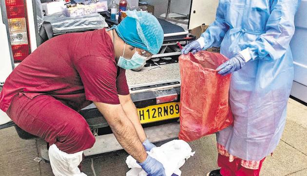 A medical professional (L) removes his PPE kit after the day’s work near Mahatma Phule Wada, in Pune. (Pratham Gokhale/HT Photo) A medical professional (L) removes his PPE kit after the day’s work near Mahatma Phule Wada, in Pune. (Pratham Gokhale/HT Photo)