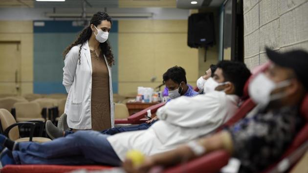 A doctor interacts with hospital employees donating blood during a donation camp at AIIMS hospital in New Delhi. There are 226,947 active cases of the viral disease as of July 2 morning, as the second phase of exiting lockdown restrictions settles into place. (Biplov Bhuyan / HT Photo)