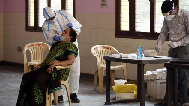 A health worker collects a swab sample for coronavirus testing in Gurgram on June 30. India has logged 5, 86, 196 confirmed Covid-19 cases of today afternoon with 17,411 deaths to the disease. The Union Home Ministry released its plan for this phase on June 29 based on feedback received from states and consultations with central ministries and departments. (Parveen Kumar / HT Photo)