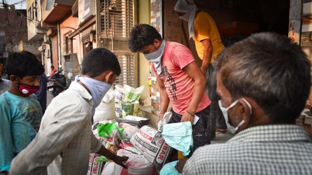 People buy essentials at a fair price shop in New Delhi on June 30. The PM Garib Kalyan Anna Yojana (PMGKAY) scheme providing free foodgrains to the needy has also been extended till the end of November. Shops, depending on their area, can under Unlock 2.0 have more than five people at a time, allowing for more business. (Sanchit Khanna / HT Photo)