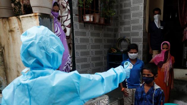 A healthcare worker checks the temperature of a resident during a medical campaign for the coronavirus disease at a slum area in Mumbai on July 1.(Reuters Photo) A healthcare worker checks the temperature of a resident during a medical campaign for the coronavirus disease at a slum area in Mumbai on July 1.(Reuters Photo)