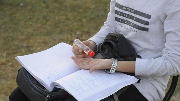 A student uses sanitizer while attending an open-air class at the Eidgah ground in the wake of the lockdown imposed to curb the spread of coronavirus in Srinagar on July 1. Prime Minister Narendra Modi on June 30 reviewed India’s preparations for vaccinating its population against the coronavirus disease (Covid-19), once such a vaccine becomes available. (Waseem Andrabi / HT Photo)
