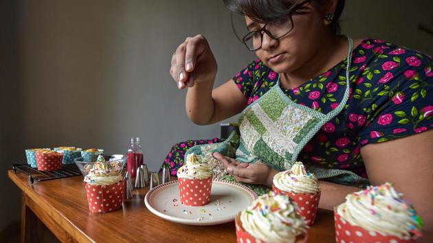 Shrutee Rane (33), a freelance illustration artist by profession, prepares cup-cakes for sale, at Vasai in Palghar district, on June 28. A lack of advertising assignments in the wake of coronavirus pandemic has forced her to turn her hobby of baking as a source of income. Rane makes a variety of cakes, breads and other confectionary items in her home kitchen and delivers it to her customers in a local circle. (Mitesh Bhuvad / PTI) Shrutee Rane (33), a freelance illustration artist by profession, prepares cup-cakes for sale, at Vasai in Palghar district, on June 28. A lack of advertising assignments in the wake of coronavirus pandemic has forced her to turn her hobby of baking as a source of income. Rane makes a variety of cakes, breads and other confectionary items in her home kitchen and delivers it to her customers in a local circle. (Mitesh Bhuvad / PTI)