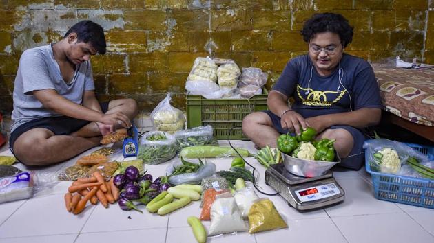 Pushkar Vishwasrao, a film-maker by profession, and Nimish Vishwasrao, a tutor by profession, pack vegetables for home delivery services in Mumbai. Both Pushkar and Nimish sell vegetables and dry snacks to sustain their livelihood amid the coronavirus lockdown. (Kunal Patil / PTI) Pushkar Vishwasrao, a film-maker by profession, and Nimish Vishwasrao, a tutor by profession, pack vegetables for home delivery services in Mumbai. Both Pushkar and Nimish sell vegetables and dry snacks to sustain their livelihood amid the coronavirus lockdown. (Kunal Patil / PTI)