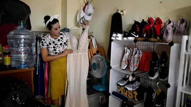 La Kim Quyen of the LGBT LoTo troupe inspects an outfit in her one-room rented accommodation before a lotto show in Ho Chi Minh City. Up until the 1990s, such performances were a regular part of rural life in the south but their appeal began to fade until Sai Gon Tan Thoi burst onto the mainstream nightlife circuit in 2017. (Manan VATSYAYANA / AFP) La Kim Quyen of the LGBT LoTo troupe inspects an outfit in her one-room rented accommodation before a lotto show in Ho Chi Minh City. Up until the 1990s, such performances were a regular part of rural life in the south but their appeal began to fade until Sai Gon Tan Thoi burst onto the mainstream nightlife circuit in 2017. (Manan VATSYAYANA / AFP)
