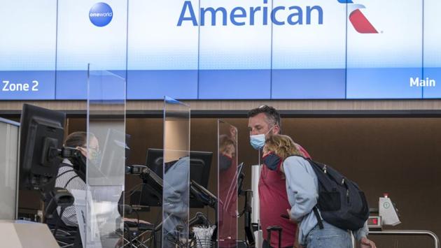 Travelers wearing protective masks check-in at the American Airlines Group Inc. counter at San Francisco International Airport (SFO) in San Francisco, California on July 1. California, which had been easing restrictions on indoor businesses like restaurants over the last month pins its surge in part to a rise in social and family gatherings. (David Paul Morris / Bloomberg) 