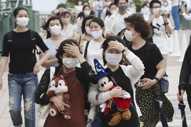 People wearing face masks to protect against the spread of the new coronavirus walk toward the entrance to Tokyo Disneyland in Urayasu, near Tokyo, Wednesday, July 1, 2020. Tokyo Disneyland reopens for the first time in four months after suspending operations due to coronavirus concerns. (AP) People wearing face masks to protect against the spread of the new coronavirus walk toward the entrance to Tokyo Disneyland in Urayasu, near Tokyo, Wednesday, July 1, 2020. Tokyo Disneyland reopens for the first time in four months after suspending operations due to coronavirus concerns. (AP)