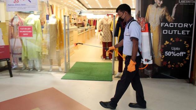 A worker sanitizes an area inside Sahara Mall as it reopens three months after closing due to the lockdown against the coronavirus, at MG road near Sikandarpur metro station, in Gurugram on July 1. (Rahul Grover / HT Photo)