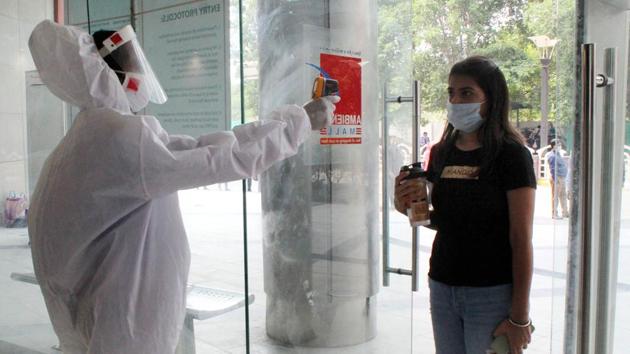 A woman undergoes thermal screening at the entrance of a shopping mall as it reopens after lockdown, in Gurugram near Delhi on Wednesday.(Rahul Grover/HT Photo)
