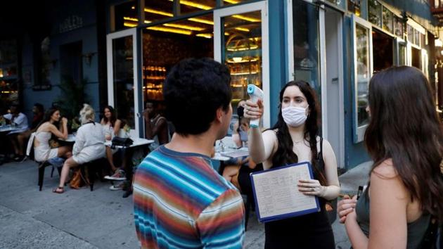 FILE PHOTO: A waitress takes the temperature of customers as they arrive to eat at Dudley's as restaurants are permitted to offer al fresco dining as part of phase 2 reopening during the coronavirus disease (COVID-19) outbreak in the Lower East Side neighbourhood of Manhattan in New York City, U.S., June 27, 2020.(REUTERS)